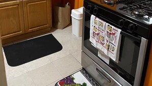 A kitchen with wooden cabinets, a stainless steel stove, and a tiled backsplash. - Charming 1-bedroom in a private house in Queens with AC, WiFi. Enjoy your stay (Queens)