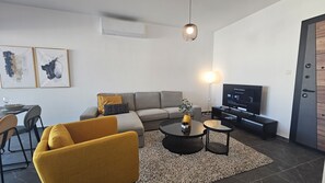 Relax in this stylish living room with a sofa, coffee table, and flat-screen TV.