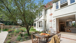 A patio with a dining table, chairs, and a tree. - Windy Ridge - sleeps 16 guests  in 6 bedrooms (Bembridge)