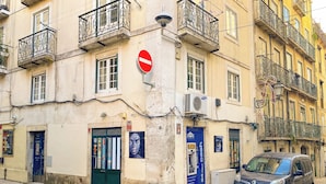 Un bâtiment avec un panneau indiquant l’interdiction d’accès, un distributeur automatique de billets bleu et une voiture garée.