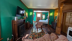 Una habitación con chimenea, televisión, cama y sofá.