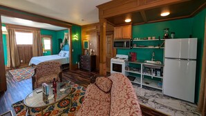 Un espacio habitable compacto con cama, sofá y kitchenette.
