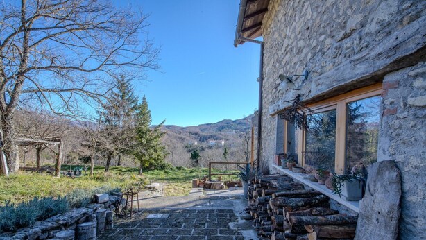 Un edificio de piedra con un sendero de piedra que conduce a una construcción de madera.