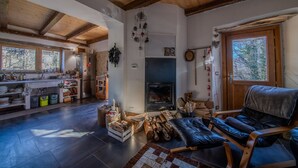 Amplia sala de estar con chimenea, un sofá y una cocina al fondo.