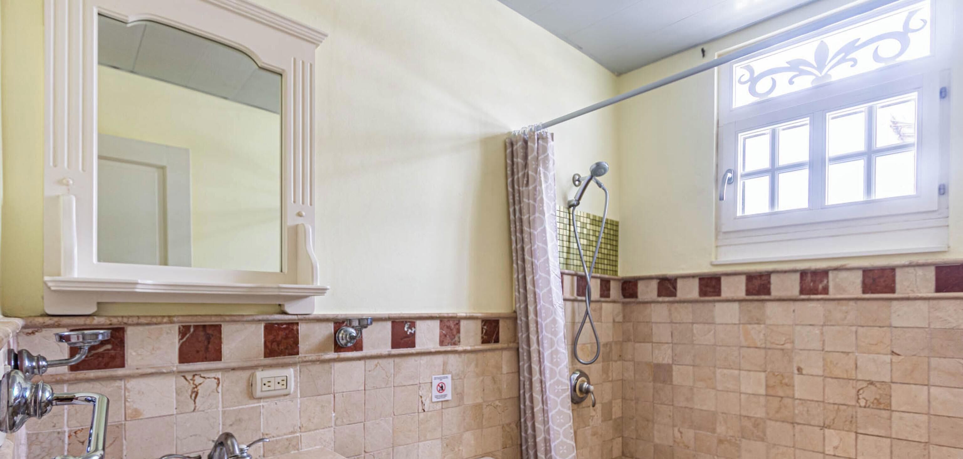 A bathroom with a sink, toilet, and shower.