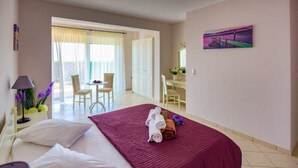 Ein Hotelzimmer mit einem Bett, einem Schreibtisch und einem Stuhl. Ein Gemälde hängt an der Wand und ein Fenster mit Vorhängen ist vorhanden.