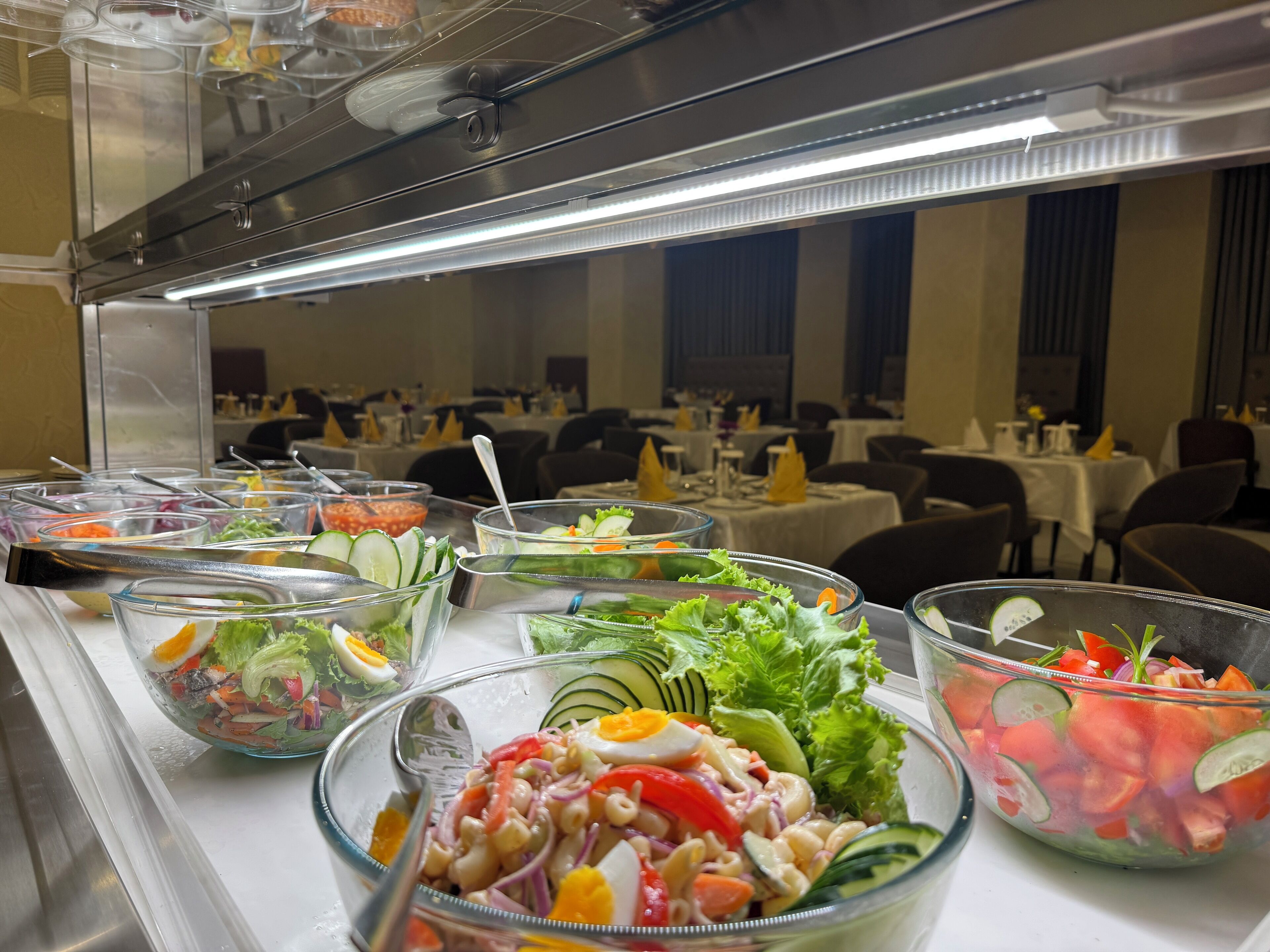 A buffet with various salads and a salad bar.