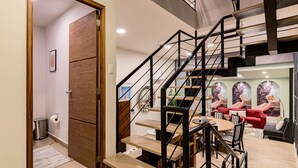 Een modern interieur met een trap, een eethoek en een woonkamer met rode banken.