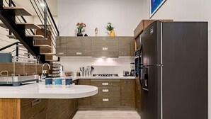 Een moderne keuken met houten kastjes, een roestvrijstalen koelkast en een inbouwoven.