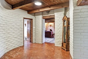 A hallway with white brick walls, wooden beams, and a brick floor. - Spacious Adobe home near Old Town in Albuquerque, New Mexico. (Albuquerque)