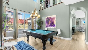 A spacious living room with a pool table, a chandelier, and a large abstract painting. - Game Lovers` Retreat: 4000 sqft of Fun (El Dorado Hills)