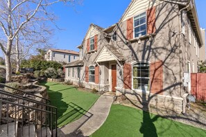 A two-story house with a stone facade, red shutters, and a well-maintained lawn. - Game Lovers` Retreat: 4000 sqft of Fun (El Dorado Hills)