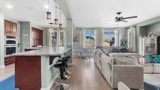 A spacious kitchen with a central island, a dining area with a table and chairs, and a living room with a sofa and chairs. - Game Lovers` Retreat: 4000 sqft of Fun (El Dorado Hills)