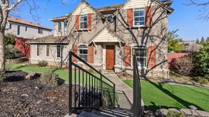 A two-story house with a front porch, a stone foundation, and a well-maintained lawn. - Game Lovers` Retreat: 4000 sqft of Fun (El Dorado Hills)