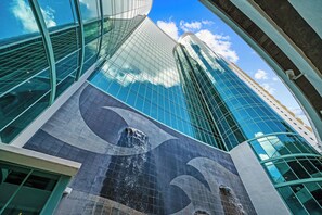 Un bâtiment moderne doté d’une façade en verre incurvée et d’un élément de design ondulé particulièrement visible.