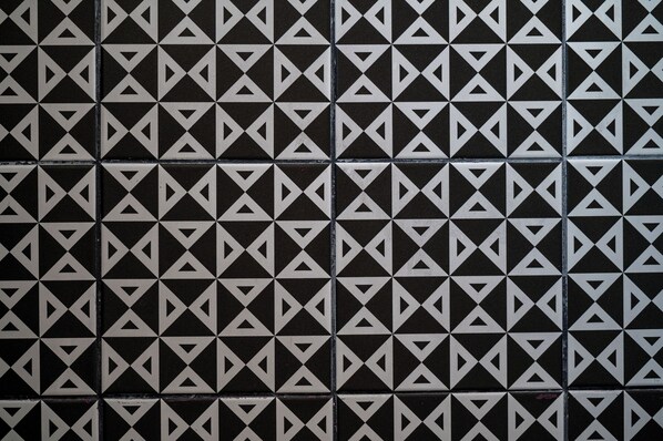 A tiled wall with a repeating geometric pattern.