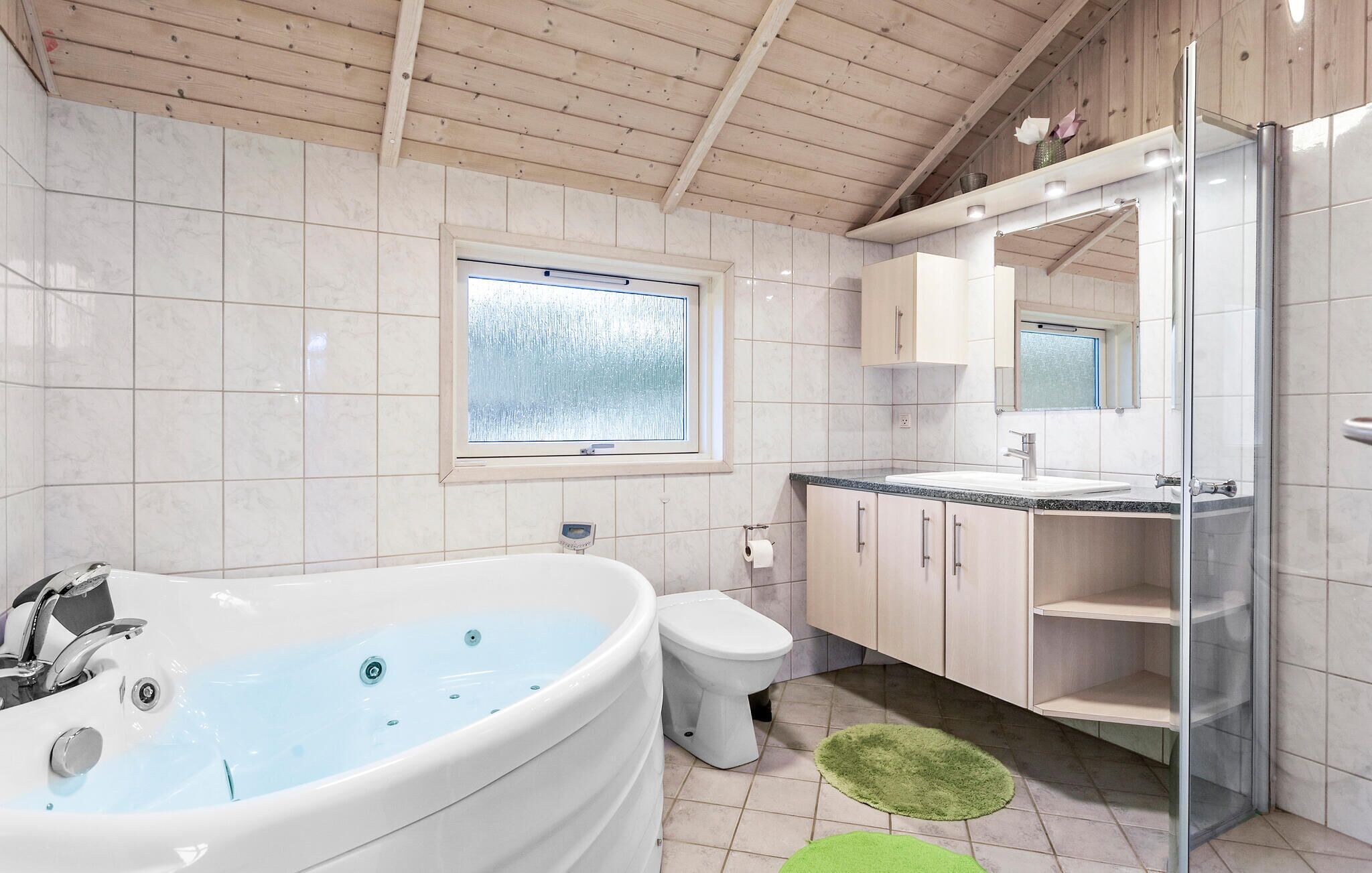 Een moderne badkamer met een vrijstaand bad, een toilet, een wastafel en een douchehoek.