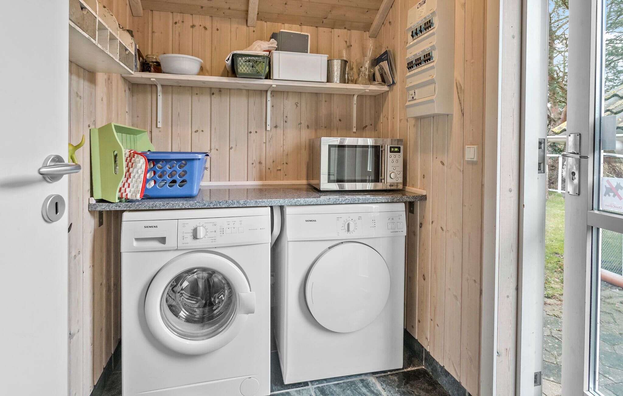 Une cuisine compacte équipée d’un lave-linge, d’un four à micro-ondes et d’un évier.