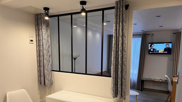 A modern room with a large window, a white desk, a white chair, and a television on the wall. - Standing apartment, heart of Bareges village, close to amenities, sleeps 1 to 8 (Barèges)