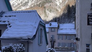 A snow-covered street with buildings and a mountain in the background. - Standing apartment, heart of Bareges village, close to amenities, sleeps 1 to 8 (Barèges)