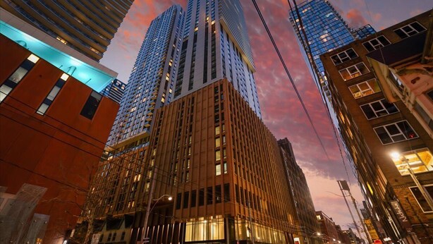 Un edificio de gran altura con un diseño arquitectónico moderno, que cuenta con varios pisos y un llamativo frente de vidrio.