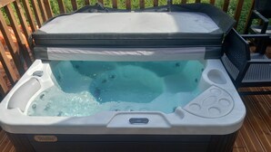 Un jacuzzi con panel de control, reposapiés y zona de estar.