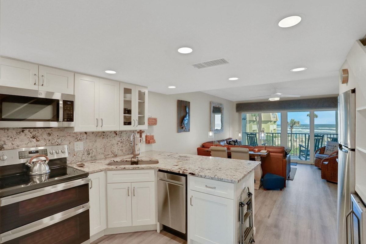 A modern kitchen with white cabinetry, a built-in microwave, and a stove.