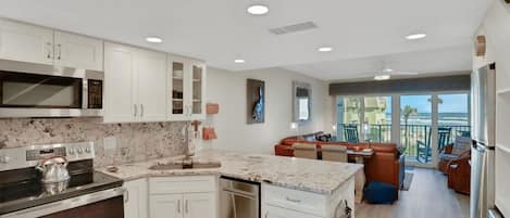 A modern kitchen with white cabinetry, a built-in microwave, and a stove.