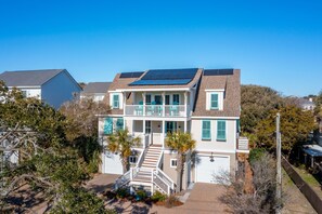 A two-story house with a balcony, solar panels, and a garage. - Luxury Beach Living, Private Pool, Easy walk to beach - The Fin House (Folly Beach)