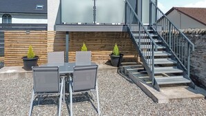 Een modern gebouw met een wenteltrap, terras en potplanten.