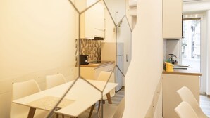 Una cocina moderna con comedor, que incluye una mesa y sillas, una isla de cocina y vista a la calle.