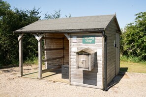 Une petite construction en bois, portant l’inscription « Magasin de confiance », avec un toit en pente, un petit porche et une porte en bois.
