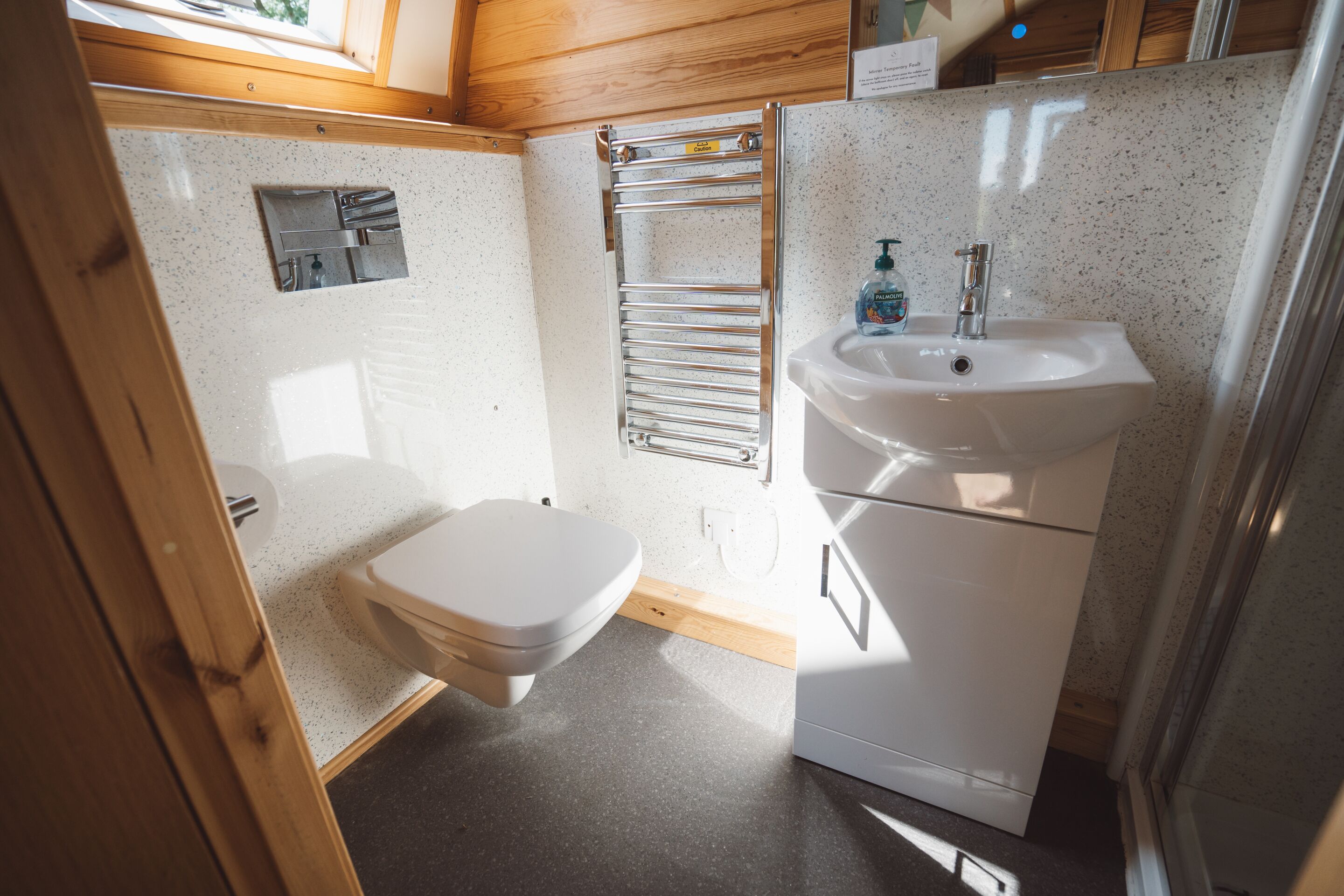 Un baño pequeño con inodoro, lavabo y barra para toallas.