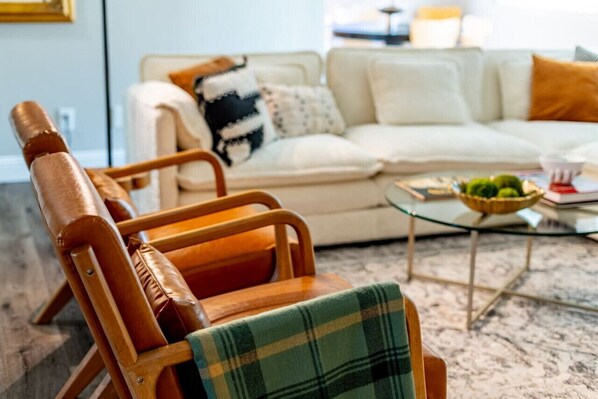A living room with a sofa, a coffee table, and a wooden chair.
