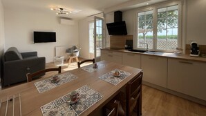 Una cocina moderna con comedor, televisor de pantalla plana y un ventanal con vistas al exterior.