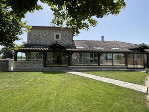 A modern house with a covered patio, a well-maintained lawn, and a clear sky. - IRONDA - LASCLAVERIES (LASCLAVERIES)