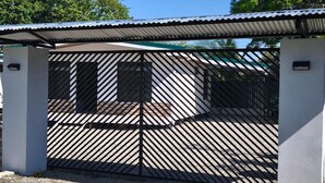 A gated area with a metal roof and a gravel ground.