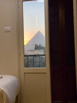 Enjoy a peaceful stay with a single bed and a view of a nearby pyramid.