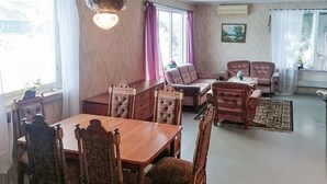 Una sala de estar tradicional con una mesa de comedor, dos sofás y un tapete estampado.