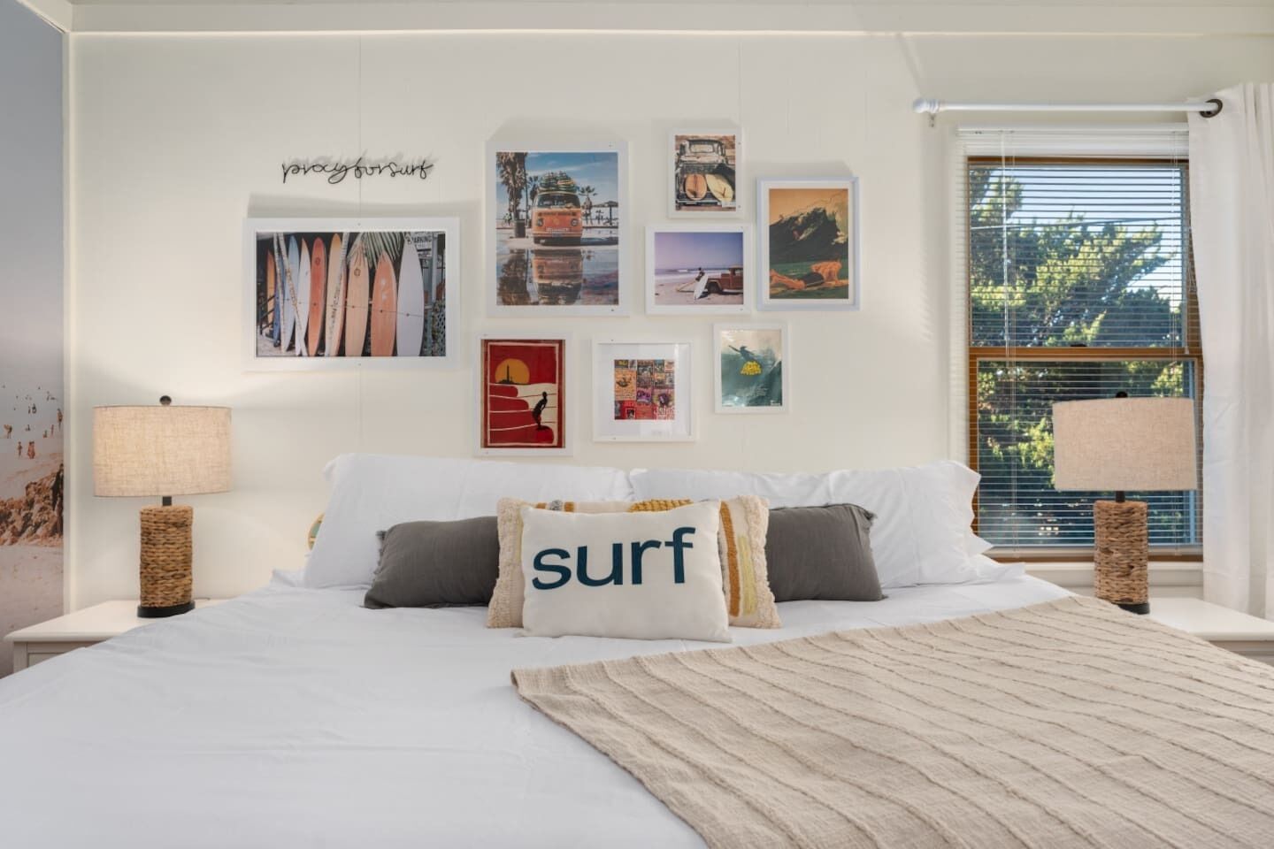 A bedroom with a bed, pillows, a rug, and wall art.