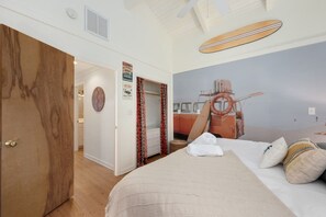 A bedroom with a bed, a wooden door, a closet, and a mural of a vintage car.