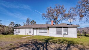 A single-story house with a chimney, satellite dish, and a small front yard.