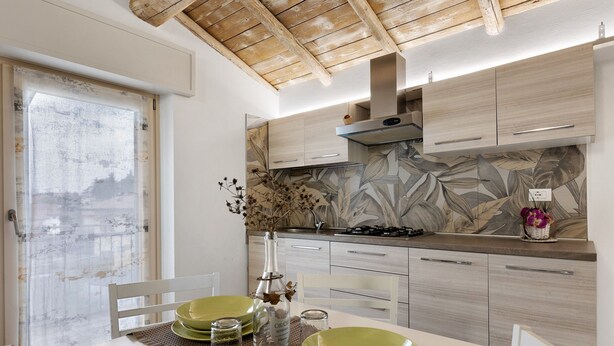 A modern kitchen with wooden cabinets, a gas stove, and a decorative backsplash.