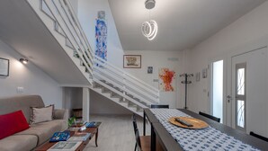 Un intérieur moderne comprenant un escalier, un coin repas et un salon.