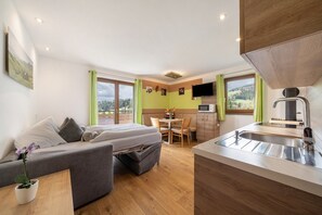 Une chambre moderne équipée d’un lit, d’un canapé, d’une table à manger et d’un coin cuisine.