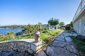 A stone pathway leading to a building with a view of a body of water. - Studio 'Dolphin 2' with Sea View, Wi-Fi and Air Conditioning (Paxos)