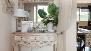 A vintage-style dresser with a mirror, a welcome sign, decorative jars, and a potted plant. - Holiday Home 'Susana' with Private Pool, Private Terrace and Wi-Fi (Santa Eulària des Riu)