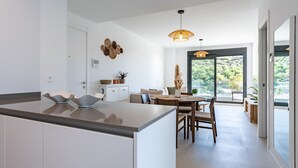 A modern kitchen with a central island, a dining area with a table and chairs, and a large sliding glass door leading to an outdoor area. - Apartment 'Middle Views West' with Sea View, Wi-Fi and Air Conditioning (Fuengirola)