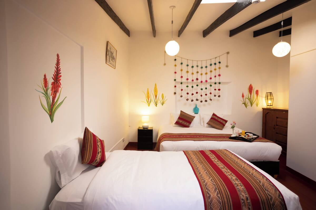 Une chambre d’hôtel avec deux lits, une décoration suspendue et un plafond en bois.
