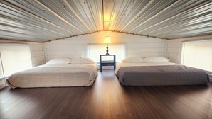 A room with two beds, a nightstand, and a lamp. - Cabin of Western Skies:  loft, Wi-Fi , and tiny home living-close to OSU (Perkins)